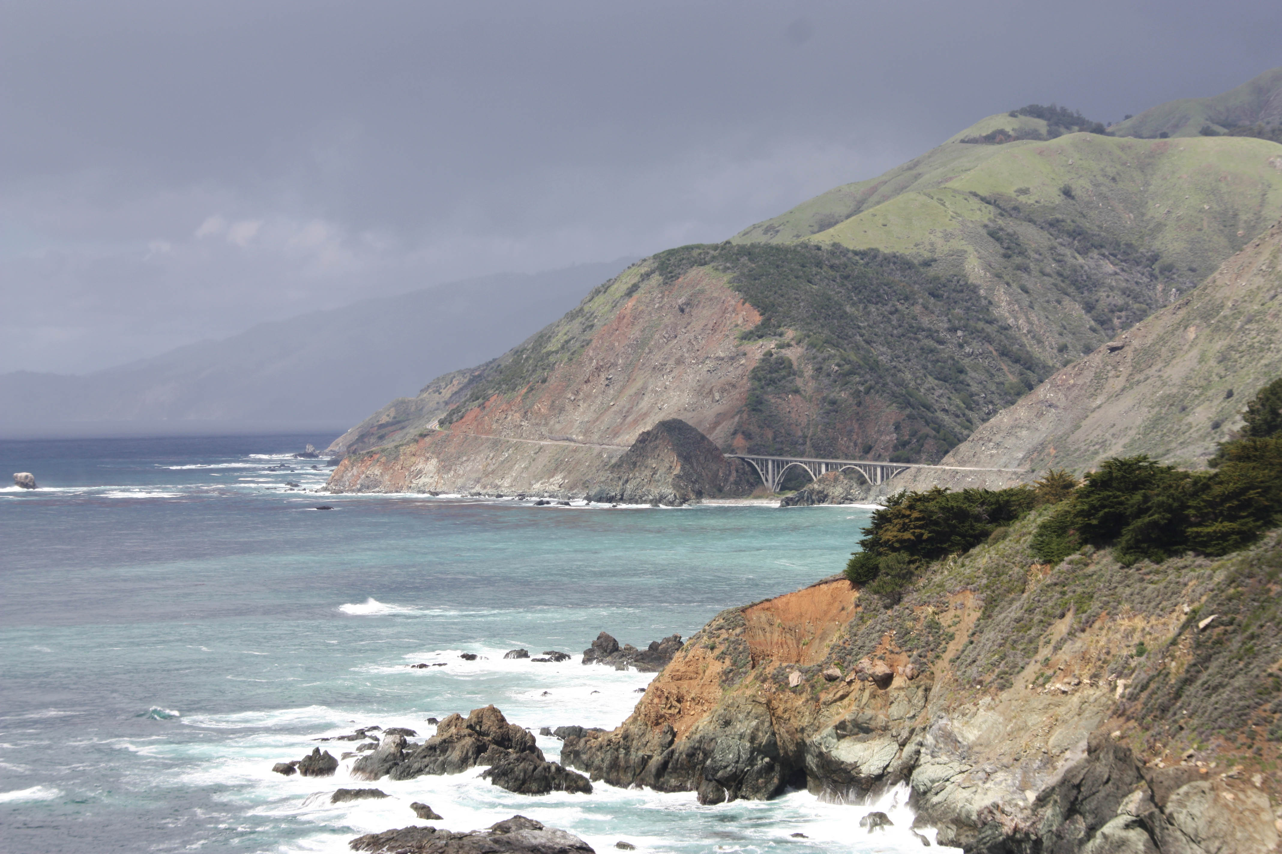 Big Sur coastline with dark rain clouds hovering above.